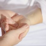 close up of a person's hand receiving massage treatment
