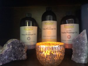Ayurvedic Massage Oils with a lit candle placed in front of them